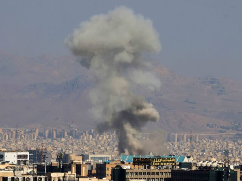 TOPSHOT - Smoke billows following an explosion in central Tehran on June 15, 2025. Iranian