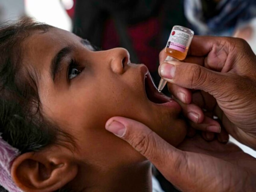 A health worker administers a polio vaccine to a child at a hospital in Deir al-Balah, cen