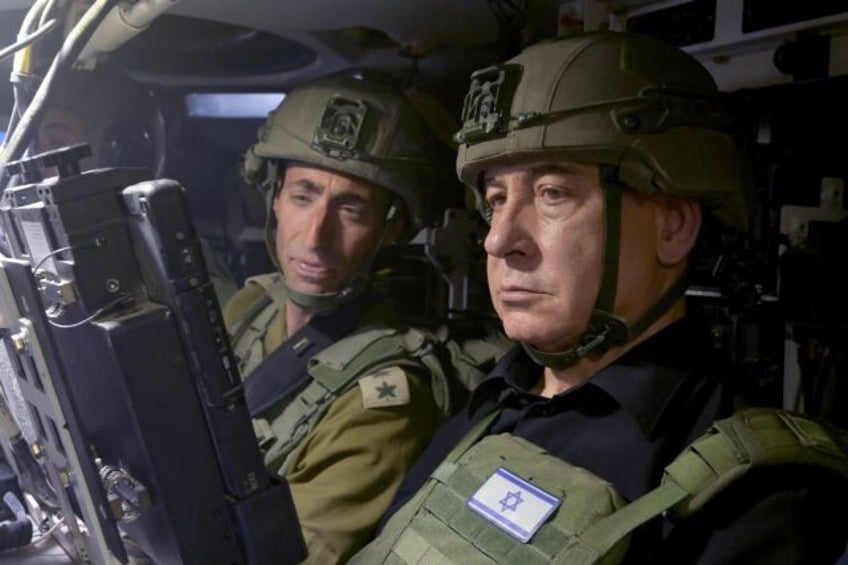 Israeli Prime Minister Benjamin Netanyahu (R) is seen visiting troops in Gaza's southernmo