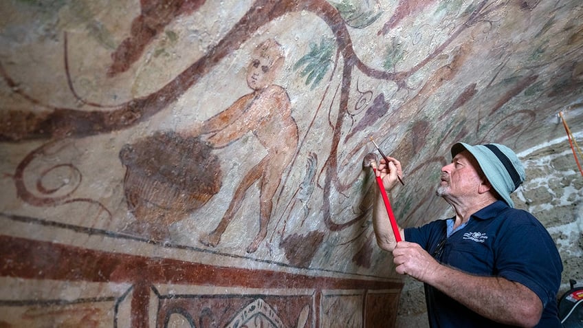 Restorer working on Ashkelon tomb mural restoration