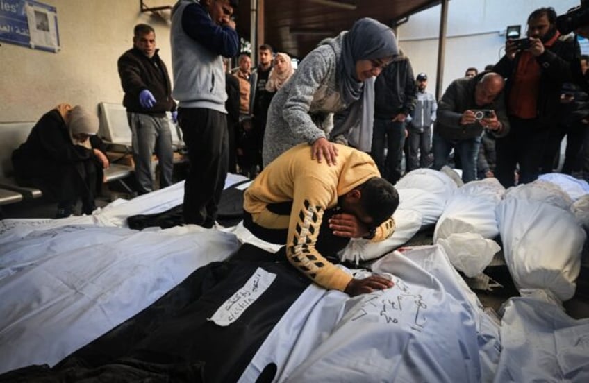 Palestinians mourn over shrouded bodies of relatives killed in overnight Israeli bombardme