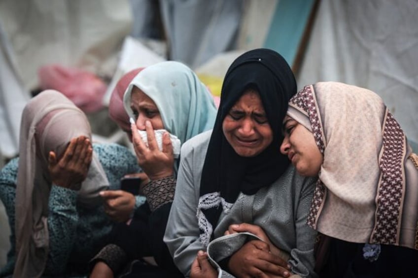 Palestinians mourn their relatives, killed in an overnight strike on the Al-Maghazi refugee camp, during a mass funeral at the Al-Aqsa hospital in Deir Al-Balah, in the central Gaza Strip, on December 25, 2023