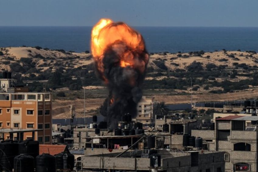 A ball of fire rises above a building during an Israeli strike in Rafah