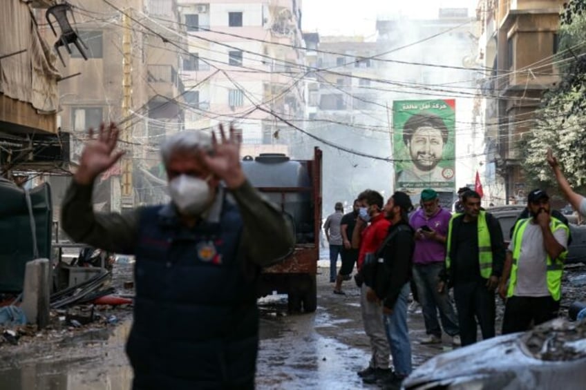 People and rescuers at the site of an Israeli air strike in Beirut's southern suburbs