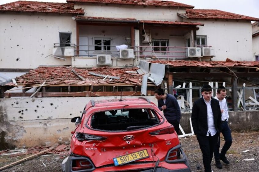 Residents in Petah Tikva near Tel Aviv inspect the damage after rockets were fired from Le