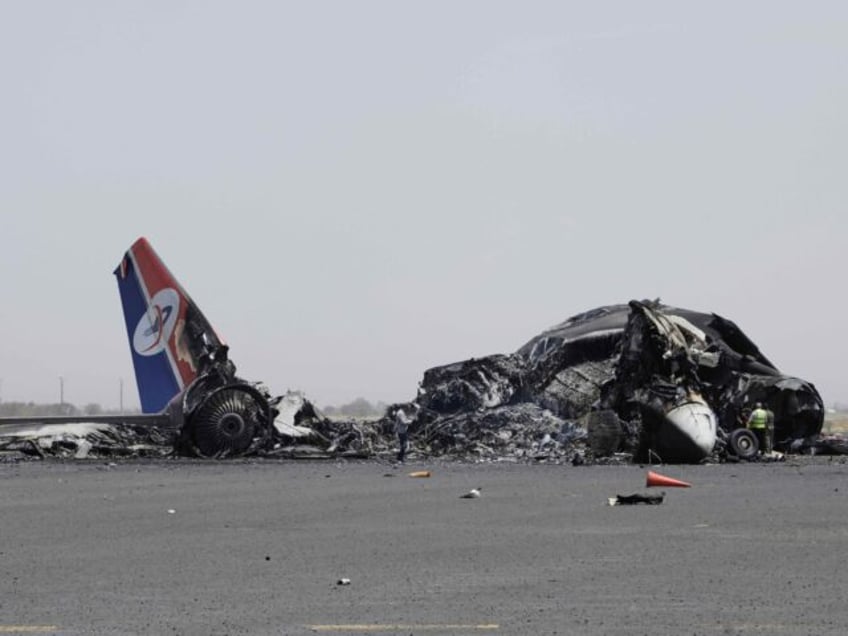 Yemenis inspect wreckage of a destroyed civilian aircraft following Israeli airstrikes on