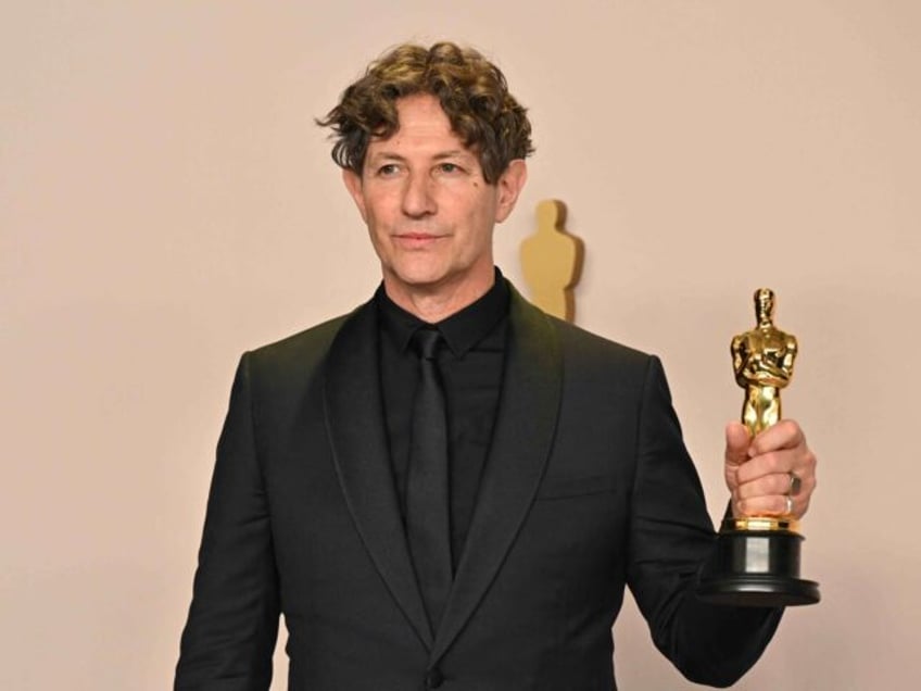 TOPSHOT - English director Jonathan Glazer poses in the press room with the Oscar for Best