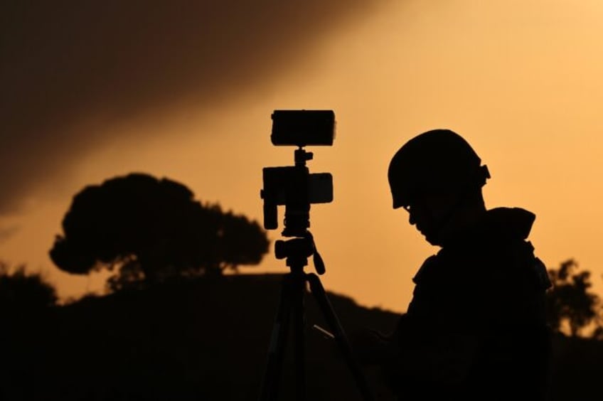 A member of the media stands behind his camera at a spot overlooking the Gaza Strip in the