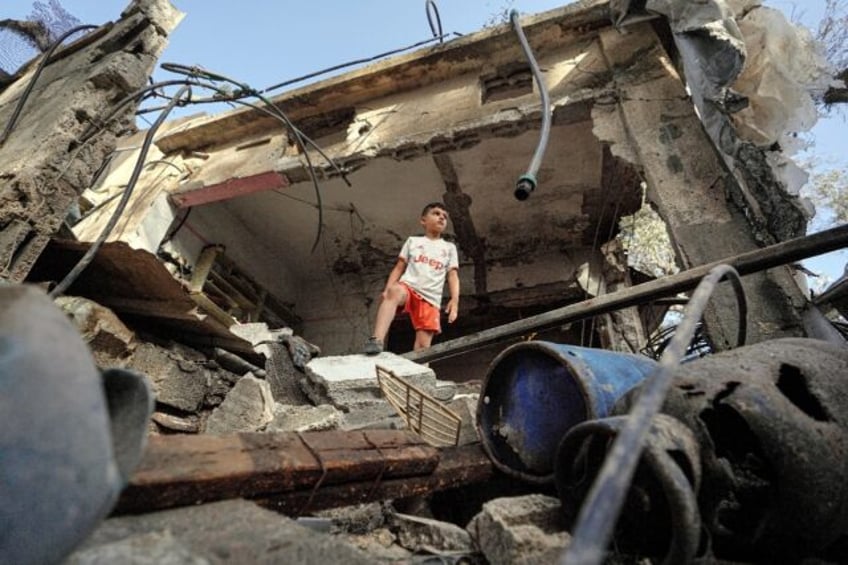 A Palestinian boy stands in a destroyed house in Gaza's Nuseirat area following Israeli bo
