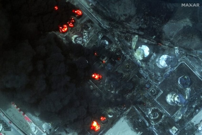 This handout satellite image released by Maxar Technologies shows burning oil tanks in the