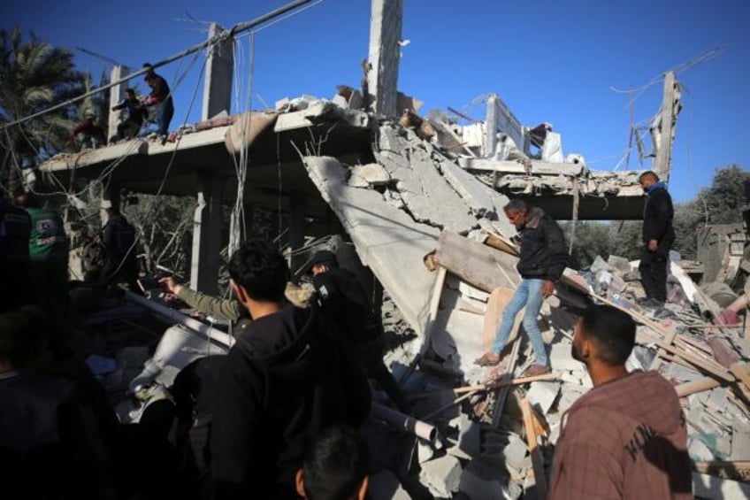 Palestinians inspect the rubble of a house in Deir al-Balah on Tuesday after an Israeli strike