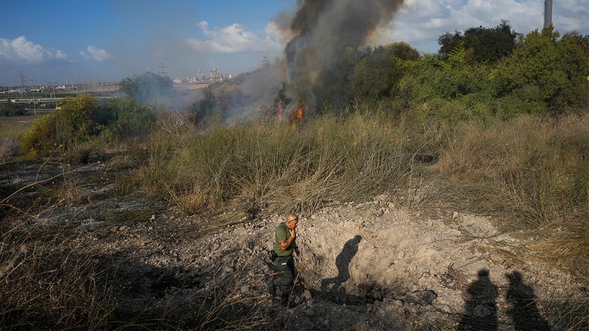 A police officer inspects the area around a fire