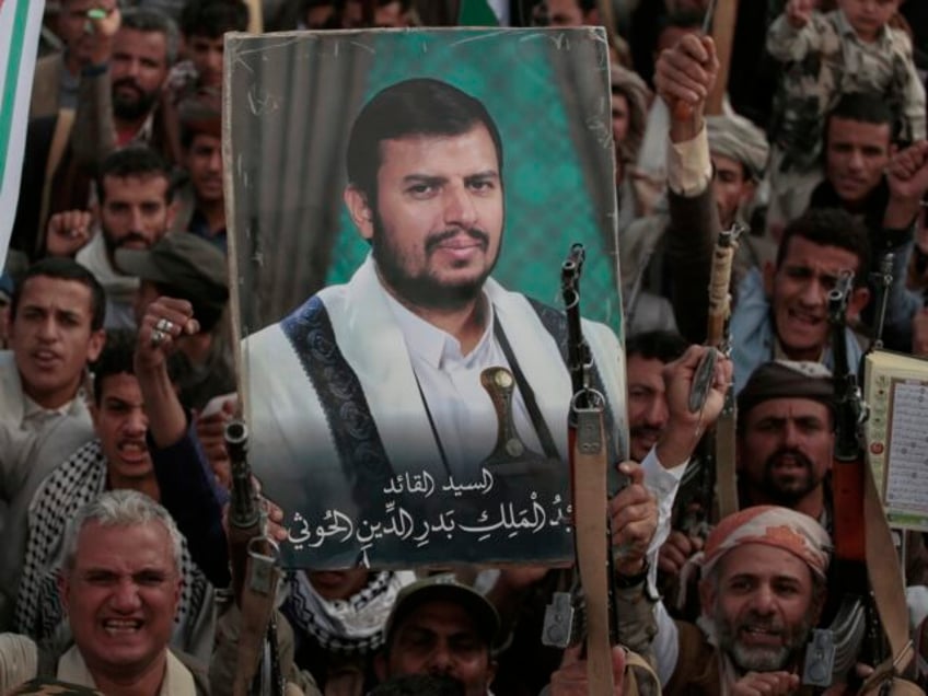 Houthi supporters chant slogans and hold pictures of Abdul Malik al-Houthi, the leader of