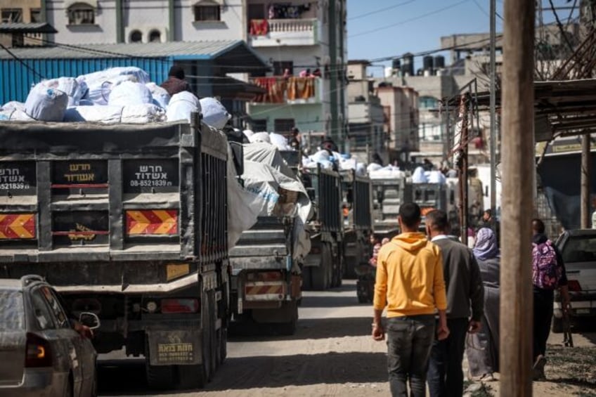 Trucks carrying humanitarian aid make their way along a street in Rafah, in March