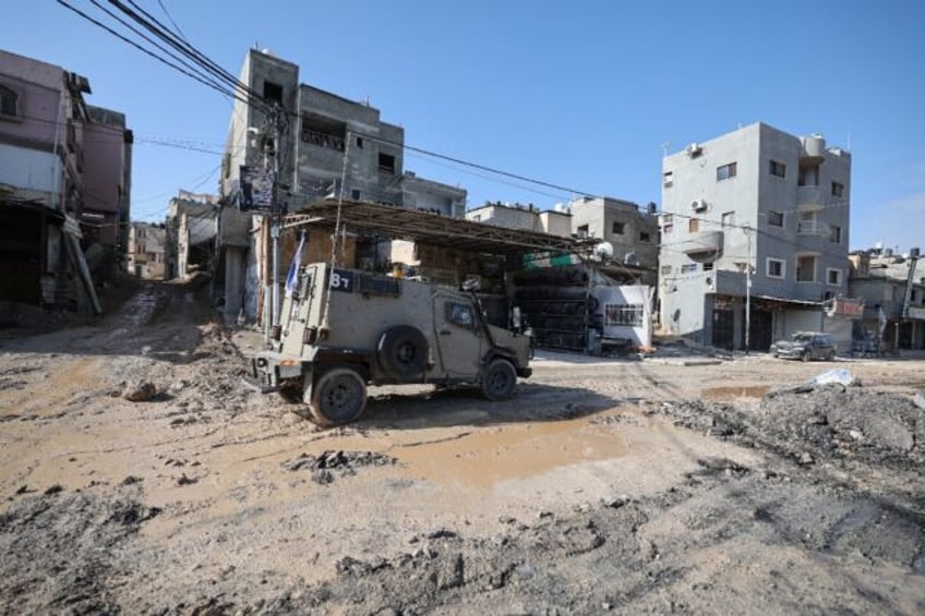 An Israeli armoured car moves through the Nur Shams refugee camp in the occupied West Bank