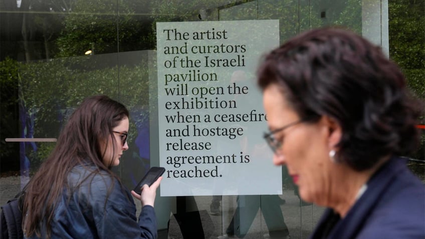 People walk by the Israeli national pavilion at the Biennale