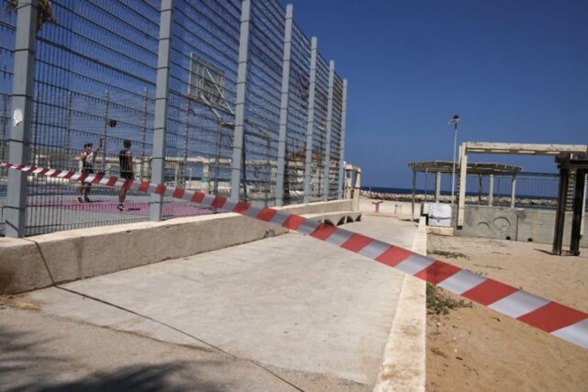 A strip of red and white tape blocks the beach entrance in the Israeli port city of Haifa