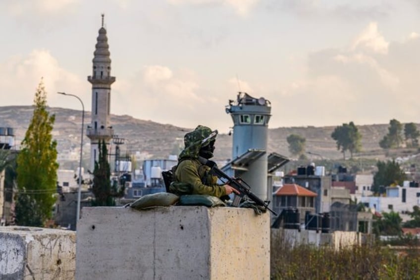 An Israeli soldier mans a checkpoint at the al-Aroub camp for Palestinian refugees south o