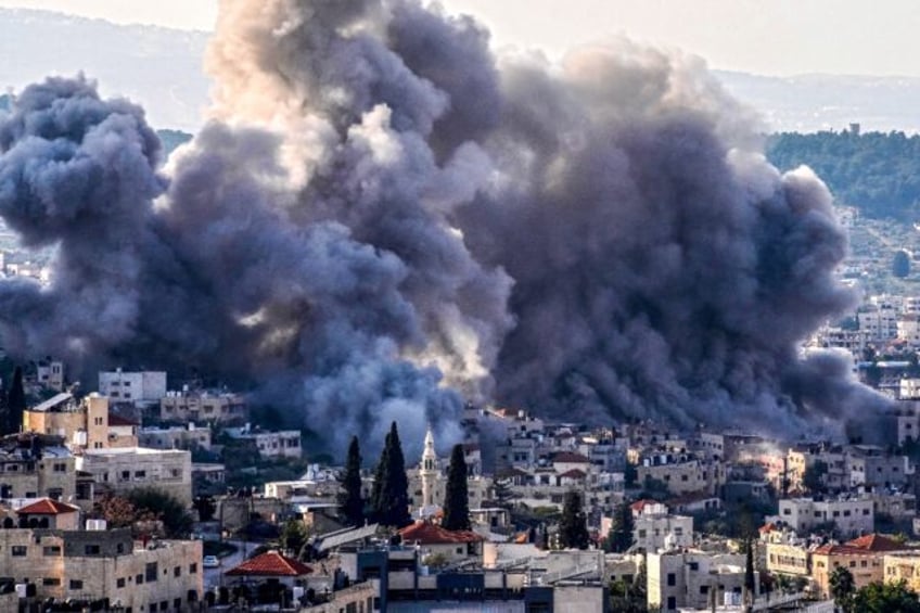 Smoke billows from the site of several explosions during an Israeli raid in the occupied W