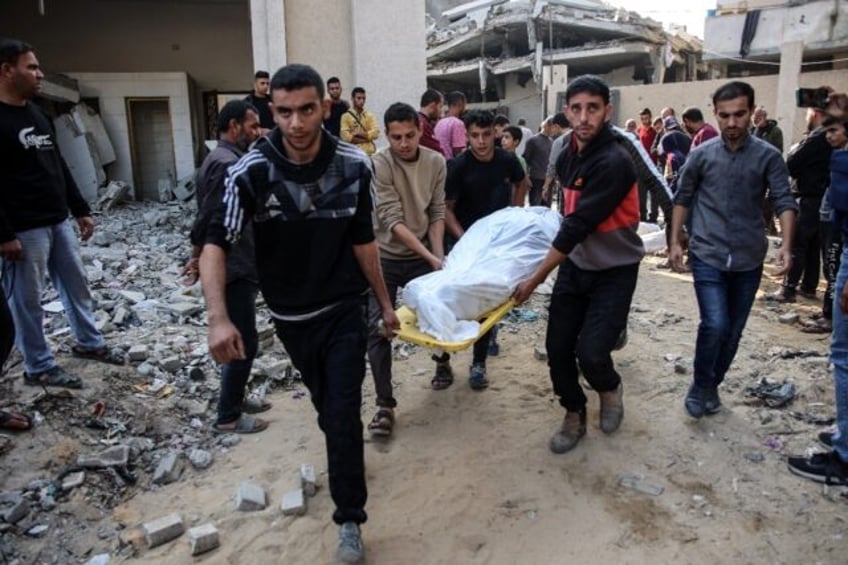 A white-shrouded body is removed from the site of the attack for burial in a Jabalia cemet