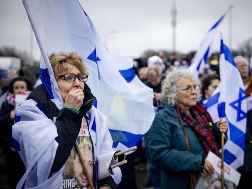 A woman reacts while watching a footage of the October 7 Hamas' attack on Israel duri