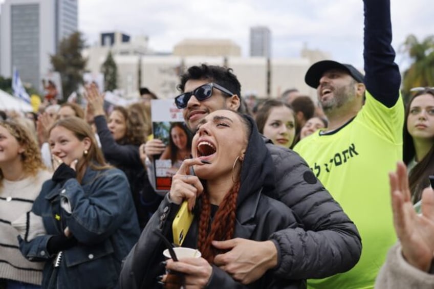 Members of a crowd gathered in Tel Aviv react during the livestreamed release of four wome