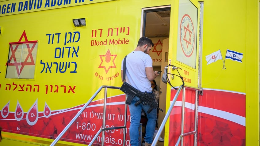 An off duty soldier waits to donate blood at a Magen David Adom mobile blood truck on March 11, 2024 in Jerusalem.