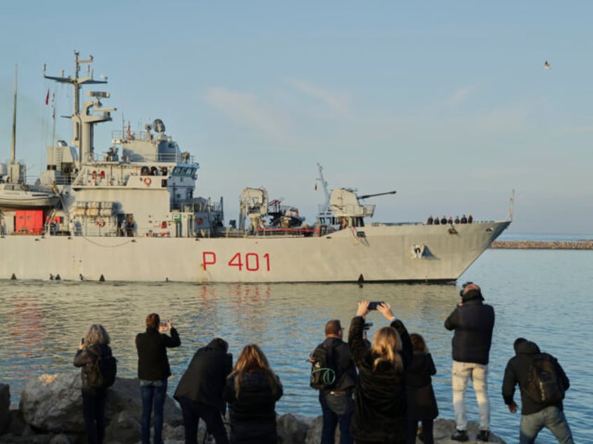 An Italian navy ship approaches the port, as Italy sends 49 more migrants to Albania for p