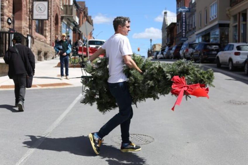 A set decorator carries a Christmas tree during filming of 'Hocus Pocus Christmas' on Apri