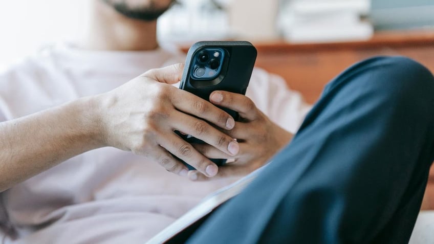 man looking at his smartphone, seated