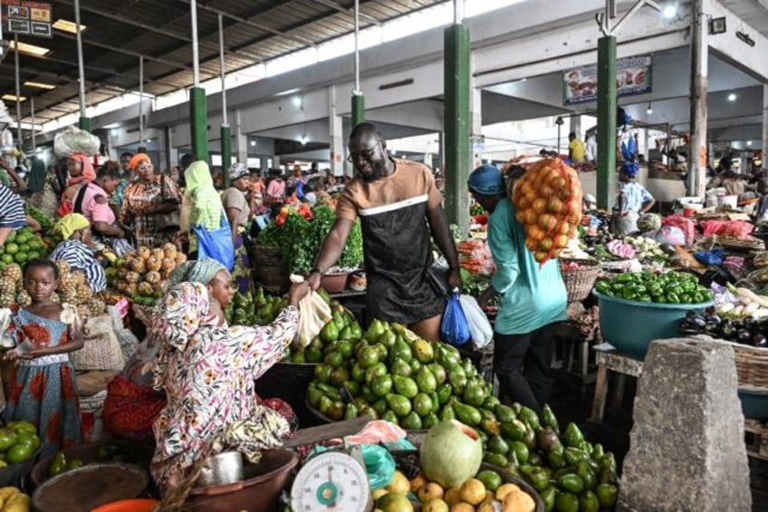 Ivorian chef Charlie Koffi (C) shops for ingredients for his gouagouassou sauce