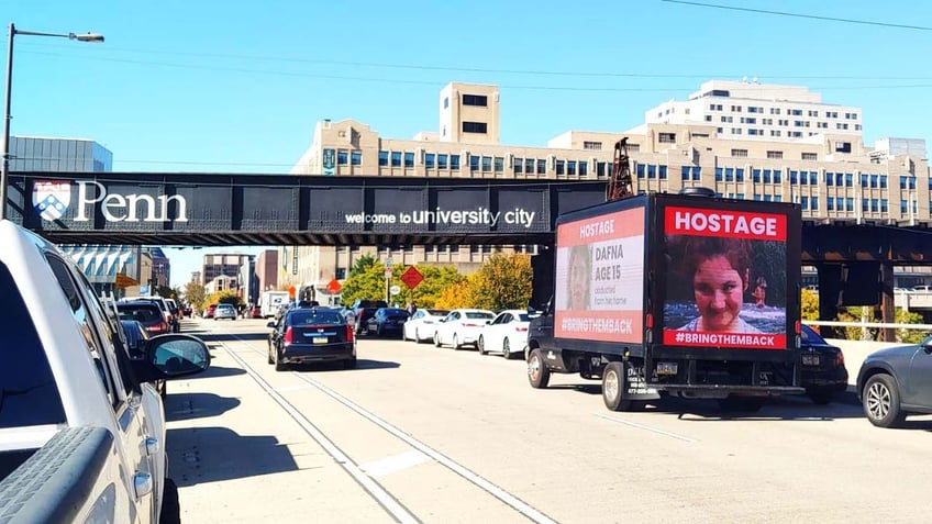 A truck displaying the names and photos of Israeli children taken as hostages by Hamas drives past the University of Pennsylvania