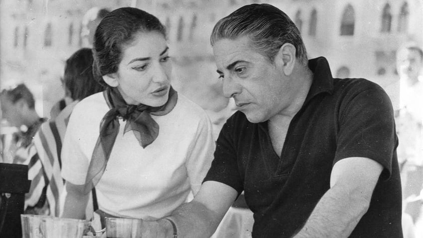 Maria Callas speaking as Aristotle Onassis looks down and serious