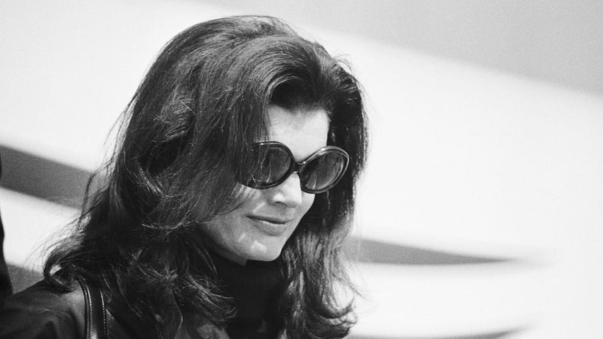 A close-up of Jackie Kennedy wearing dark sunglasses.