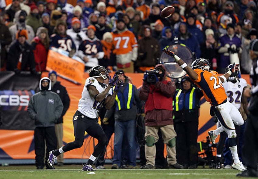 Jacoby Jones of the Baltimore Ravens catches a 70-yard touchdown reception in the fourth quarter against Rahim Moore of the Denver Broncos during the...