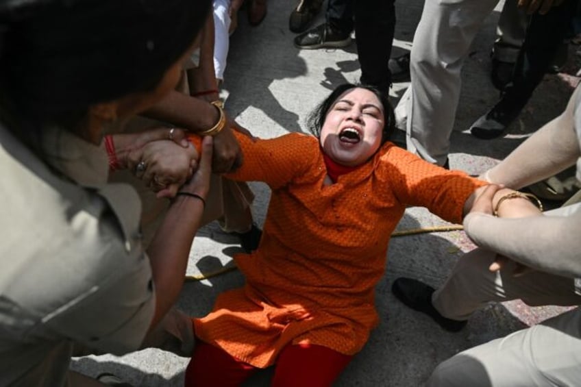 Police grab an Aam Aadmi Party activist during a protest near the residence of India's Pri