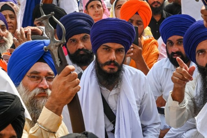 Amritpal Singh (C) temporarily left jail to be sworn into India's parliament after he won