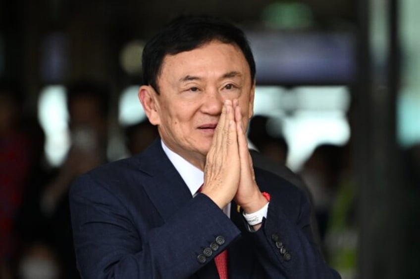 Former Thai prime minister Thaksin Shinawatra greets his supporters after landing at Bangk