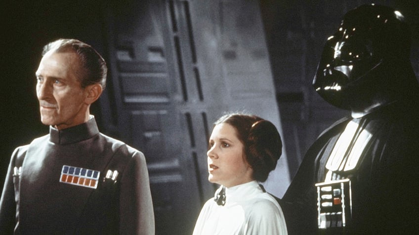 Peter Cushing, Carrie Fisher, and Darth Vader in a scene from Star Wars