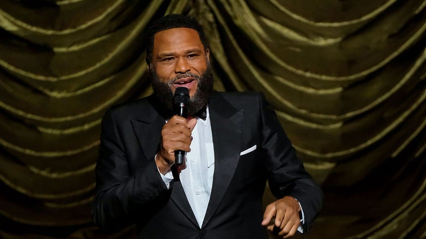 Anthony Anderson speaking on stage wearing a tuxedo