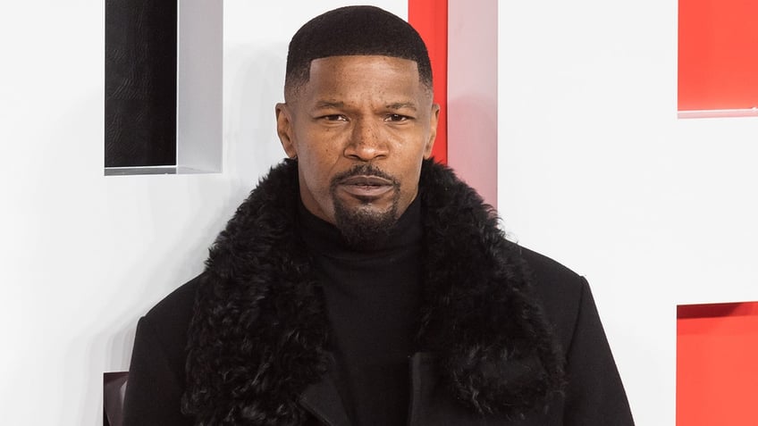 Actor Jamie Foxx wears plush black coat.