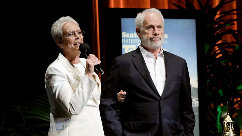 Jamie Lee Curtis wraps her arm around husband Christopher Guest.