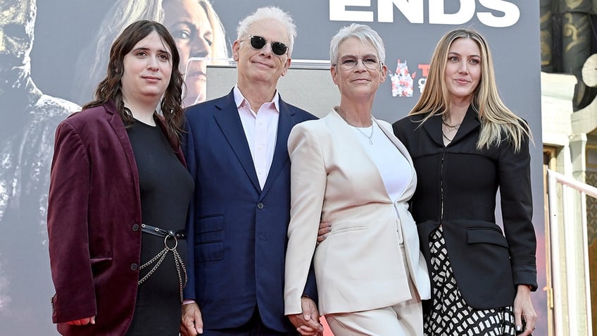 Jamie Lee Curtis holds hands with husband Christopher Guest at Halloween premiere.