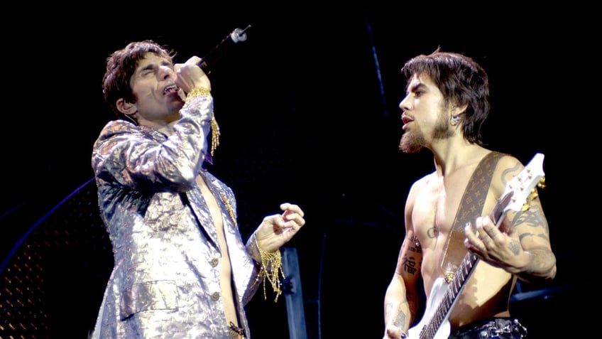 American musicians Perry Farrell (left) and Dave Navarro of the band Jane's Addiction perform onstage in 2003.