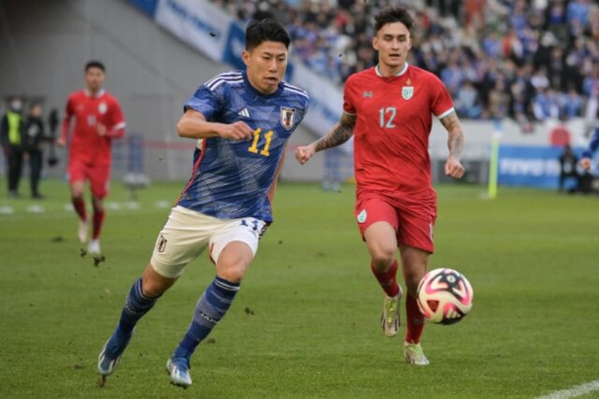 Thailand's Nico Mickelsen (R) defends against Japan's Mao Hosoya (C) during the New Year’s Day international football friendly match between Japan and Thailand