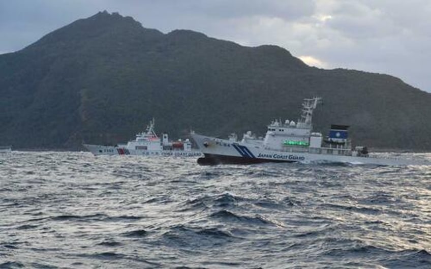 japan complains after chinese ships armed with machine guns sail near disputed islets