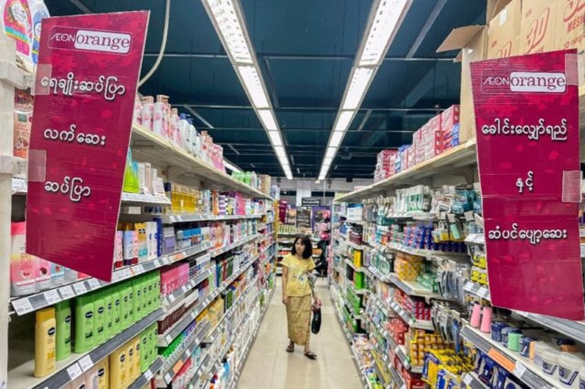 A shopper walks down an aisle at an Aeon Orange supermarket in Yangon on July 1, after Mya