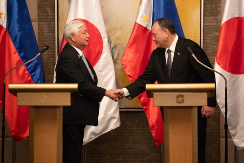 Philippine Secretary of National Defence Gilberto Teodoro (R) shakes hands with Japanese D