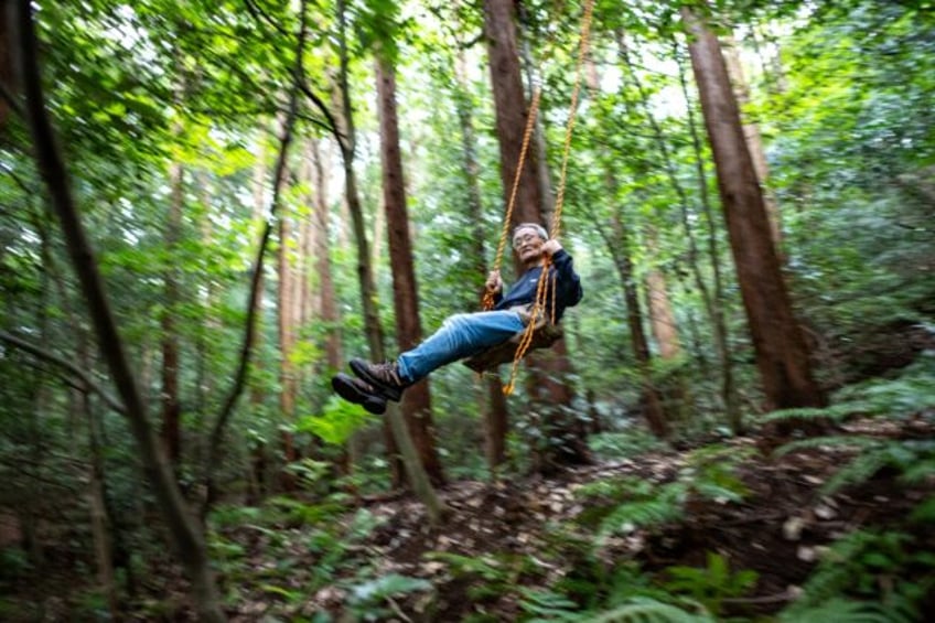 'Poop master' Masana Izawa, seen playing on a swing, says giving facese back to nature is