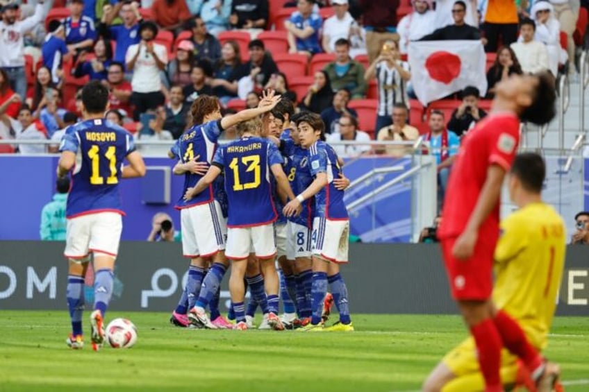 Takumi Minamino celebrates with teammates after scoring his team's second goal